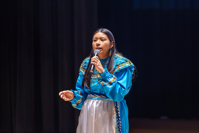 2025–2026 Miss American Indian OSU, Cydnee Miller, a Chickasaw citizen and OSU junior from Ada, Oklahoma, shares a story while wearing a traditional blue cloth Chickasaw dress.