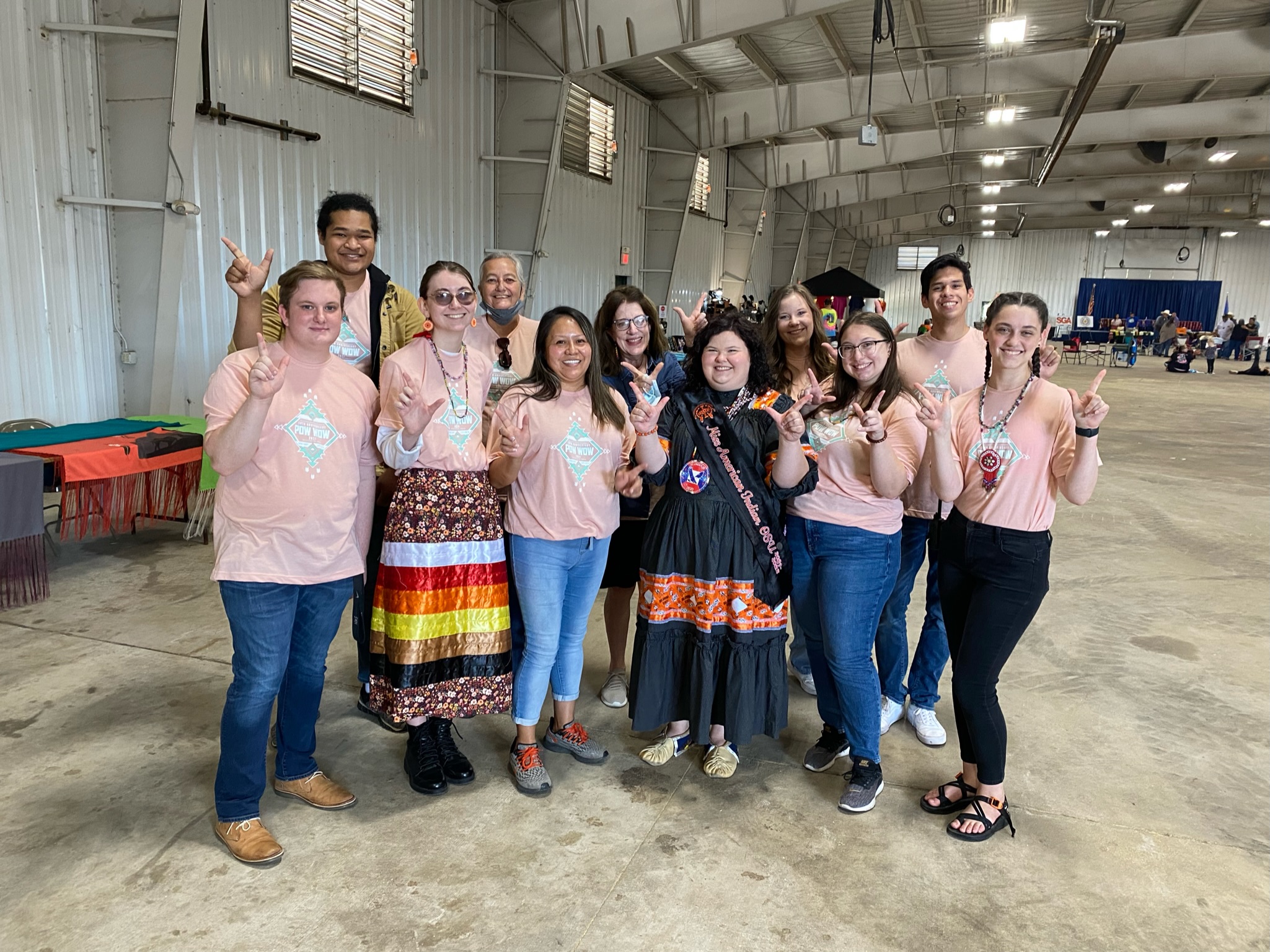 Miss American Indian OSU Kait pictured with NASA executive members at the OSU Powwow. All are wearing matching pink powwow shirts.