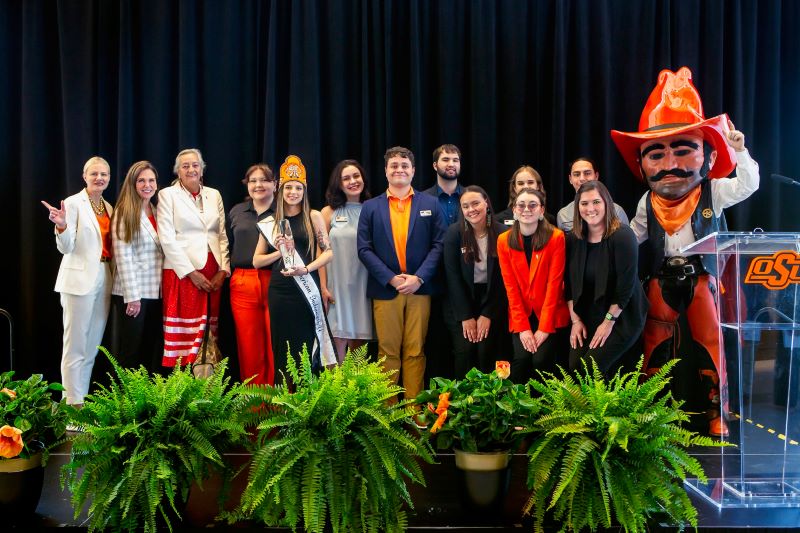Miss American Indian OSU Lauren pictured on stage with NASA executive members, OSU President Kayse Shrum, and Pistol Pete, accepting an award during the 2023–2024 event.