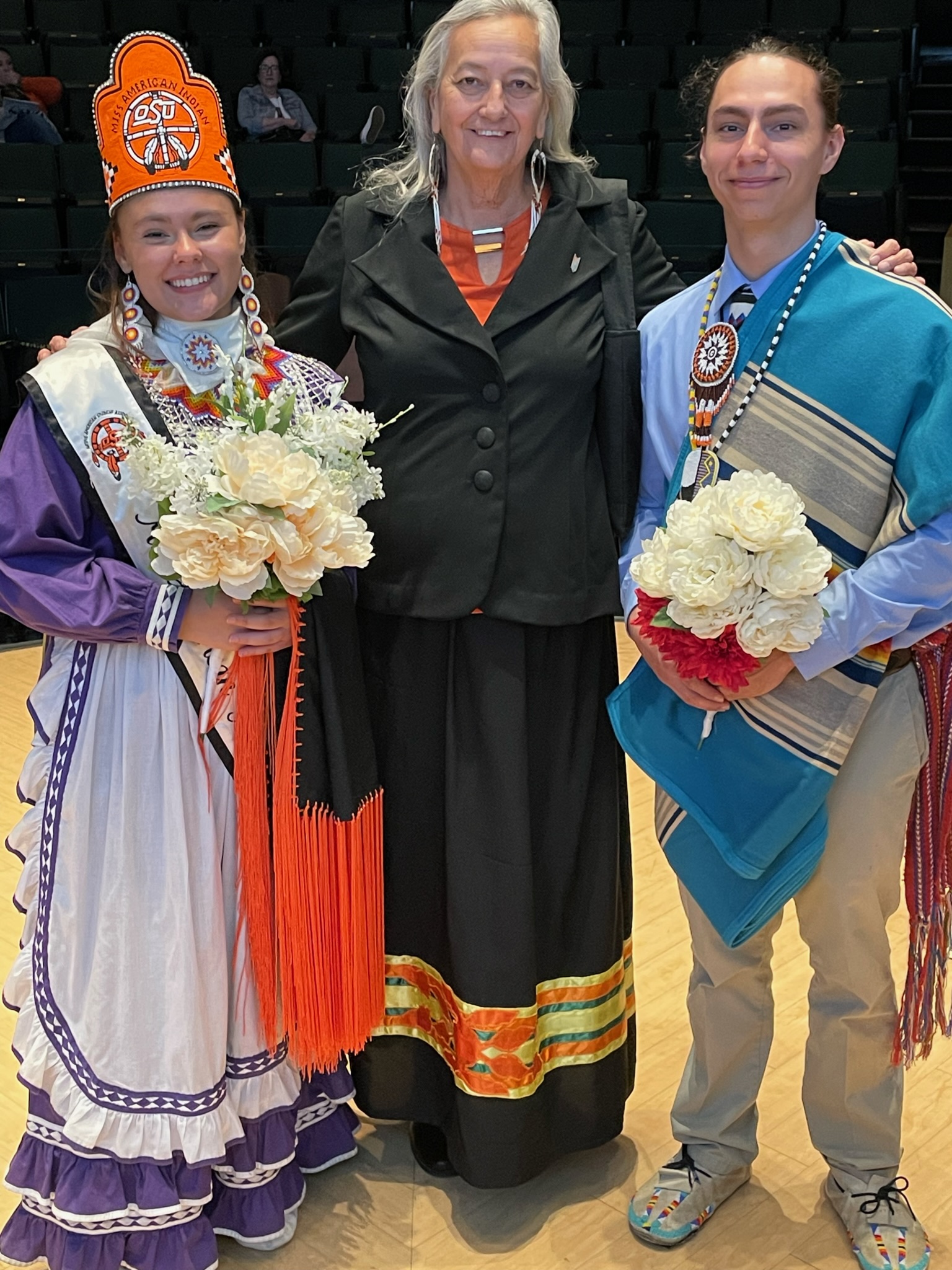 Miss American Indian OSU Shaeligh with Mr AMerican Indain OSU caleb standing next to Dawna Riding In-Hare NASA co AdvsiorPictured