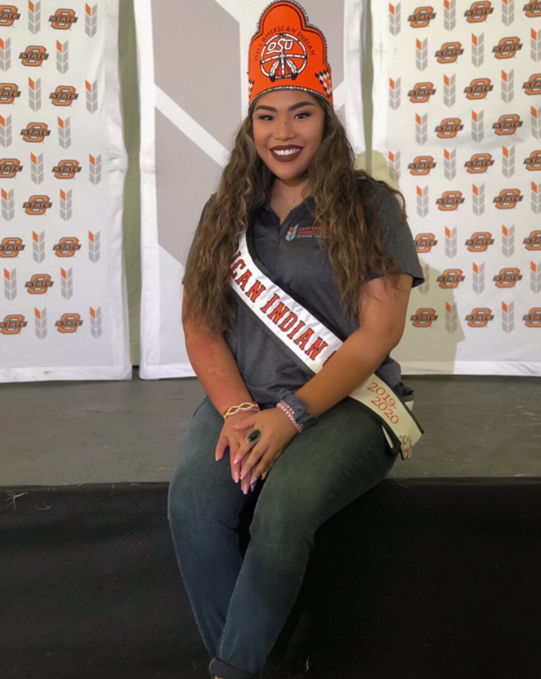 Miss American Indian OSU MaCaylin wearing crown and sash smiling in photo at Center for Soverign Nations Birthday Event