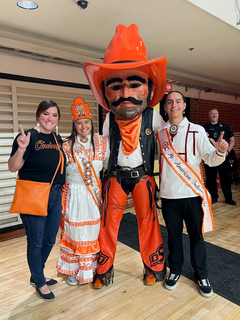Miss American Indian OSU Shaeleigh and Mister American Indian OSU Caleb, both wearing traditional clothing, posing with NASA co-advisor Sky Rogers at the N7 event.