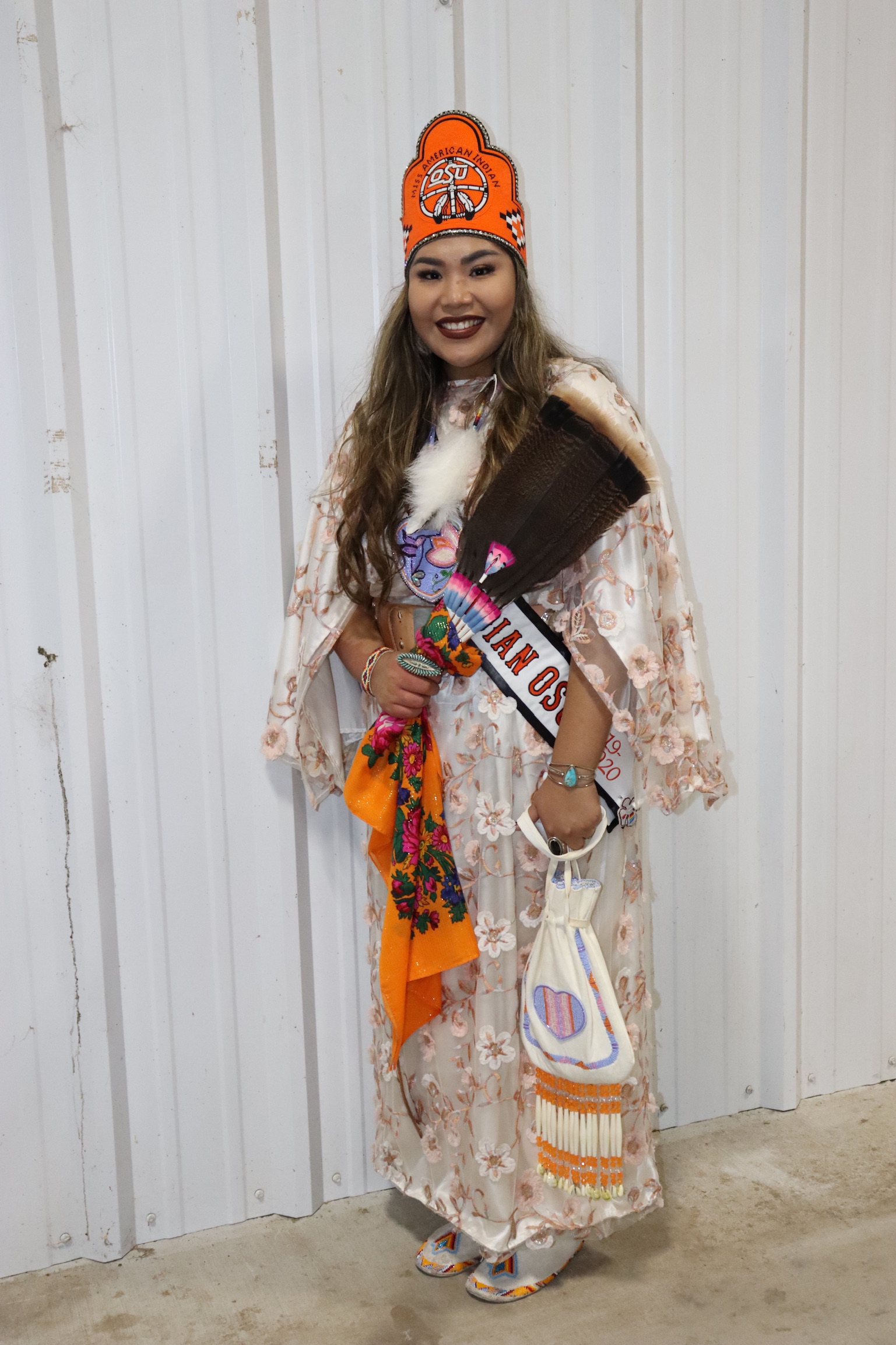 Miss American Indian OSU MaCalyin, wearing traditional clothing and the MAIOSU crown and sash, pictured smiling.