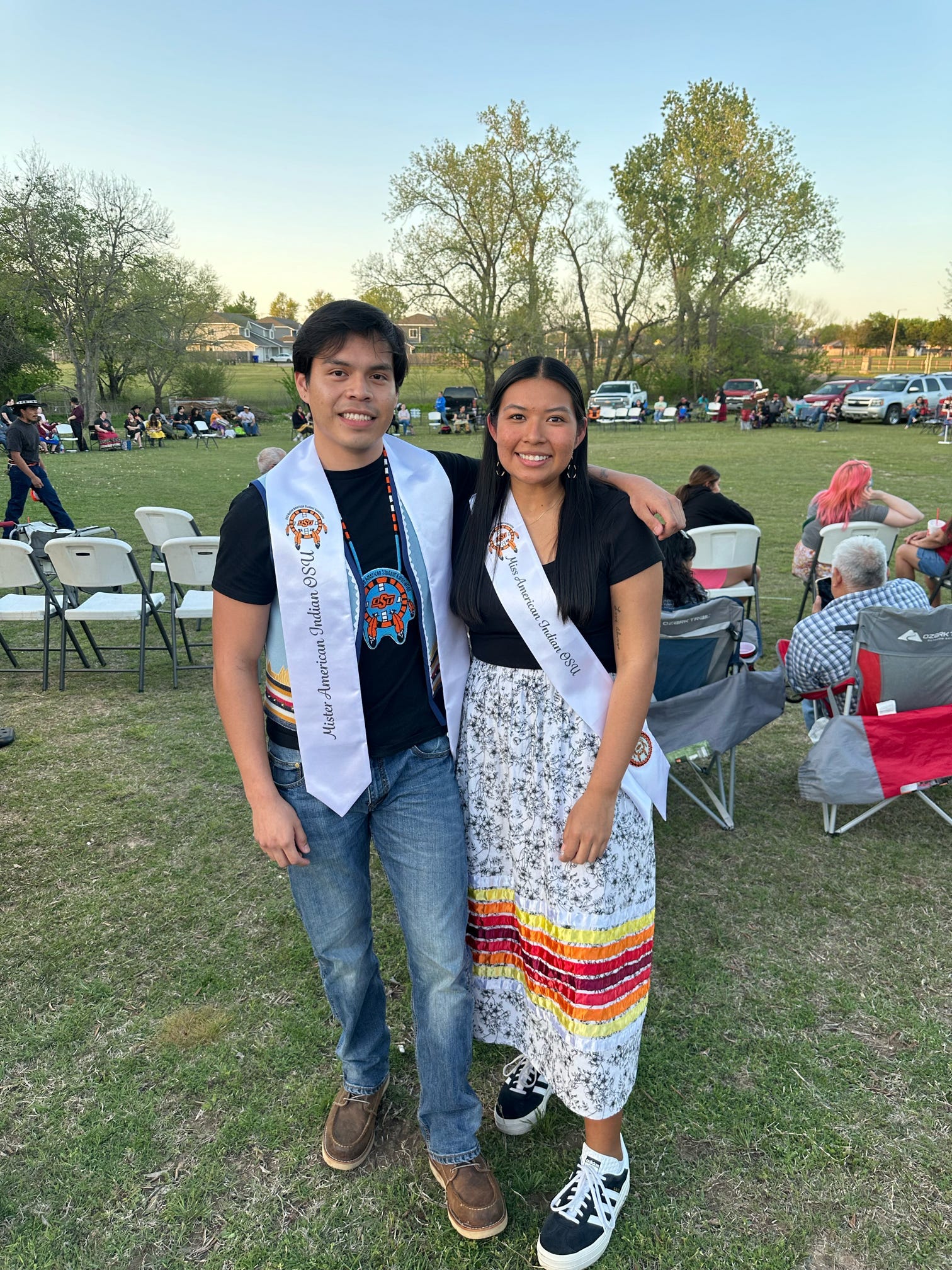 Cydnee and Jaden at a stomp dance 2025 wearing their sashes