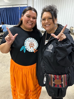 Headshot of Chenoa and Lisa at Powwow wearing ribbion